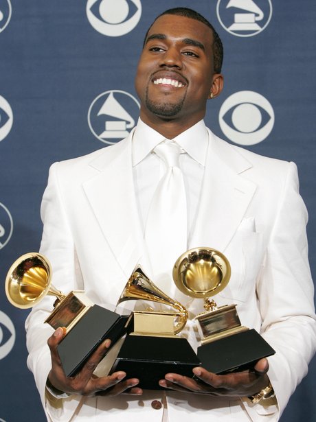 Kanye West holding his Grammy Awards in 2015
